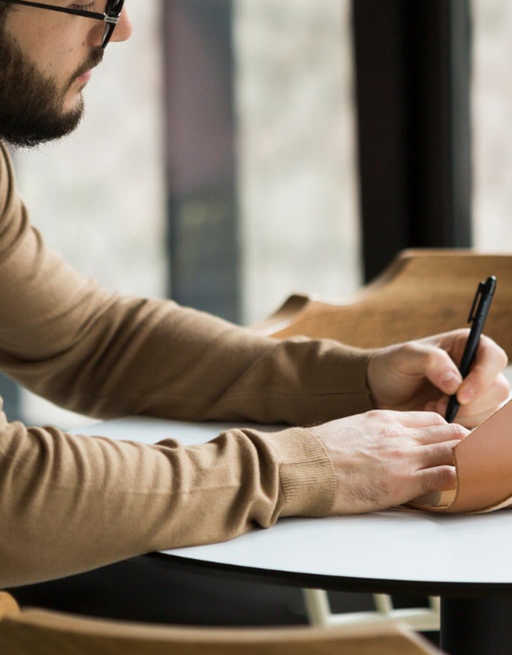 A man writing a card at his desk
